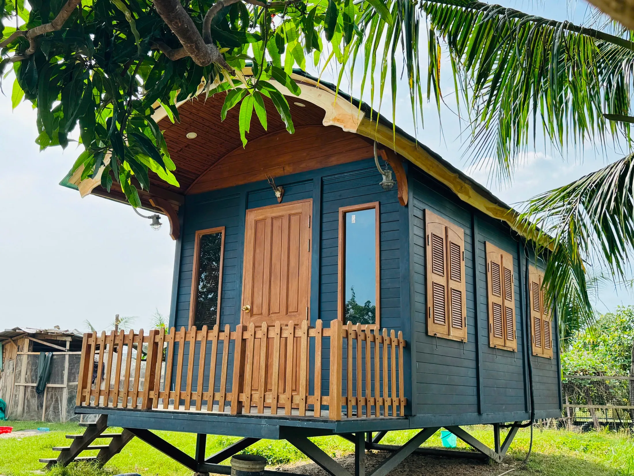 Căn nhà gỗ Ecolog House màu xanh đậm giữa khu vườn